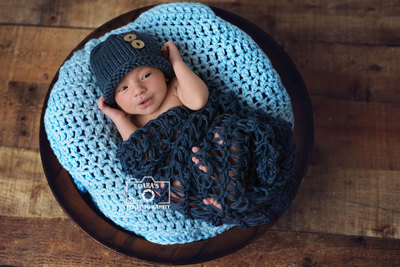 coral springs hospital newborn photographer boy in blue wrap and hat in a bowl