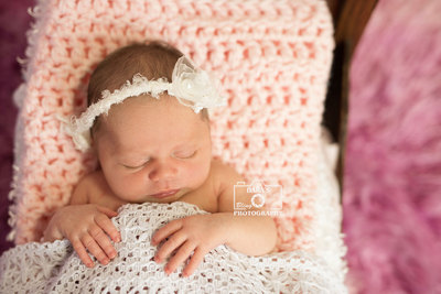 Miami newborn baby girl photography white bow headband in a bed