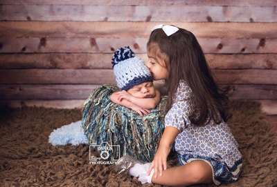 Deerfield Beach Newborn photographer big sister kissing newborn brother in a bucket