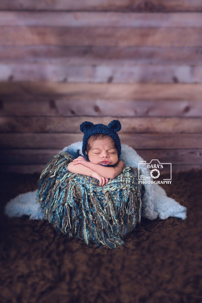 newborn baby boy in bucket blue bear hat