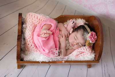 Sunny Aisles newborn photographer baby girl in pink bed