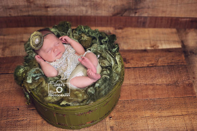 Miami newborn photographer newborn baby girl green outfit in a green fur bucket