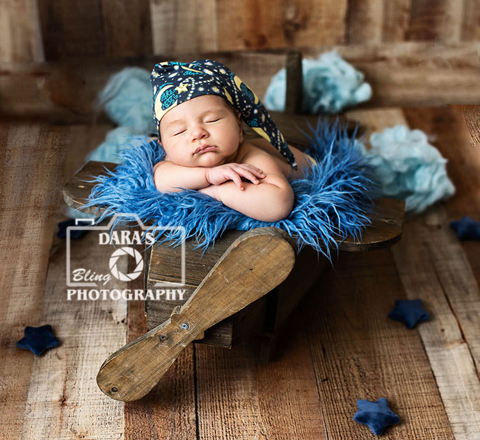 newborn baby posed in airplane prop