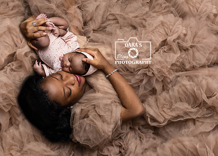 mother with newborn baby at photo shoot laying on floor